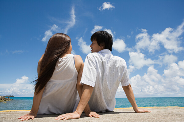 坐在海边依偎在一起谈话的情侣图片图片