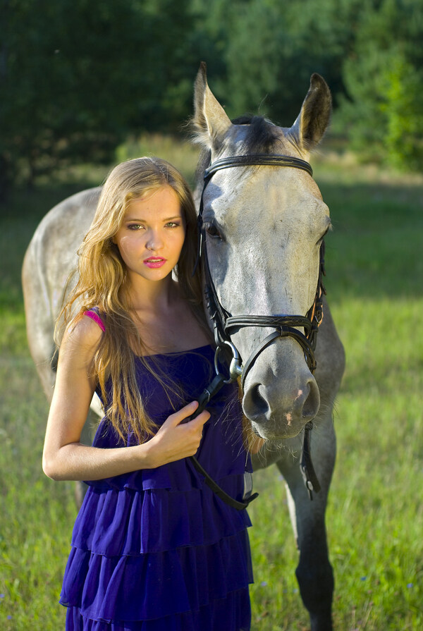 草地上牵着马的美女图片