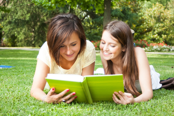 草地上看书的外国女生图片