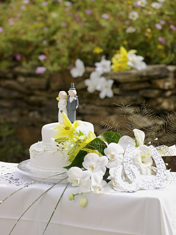 桌子上的婚礼蛋糕和花帽图片
