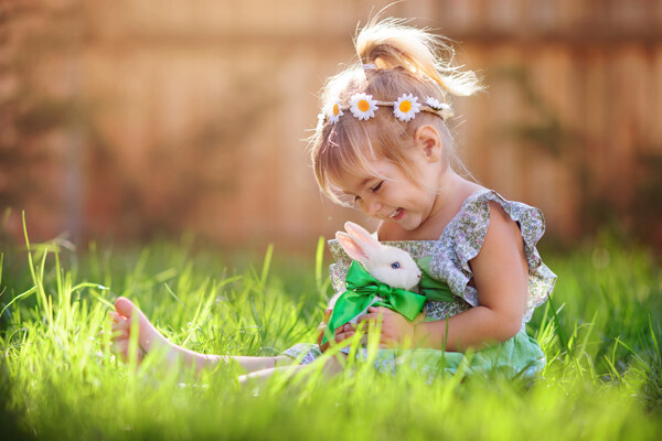 草地上抱着兔子的女孩图片