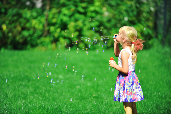 草坪上吹泡泡的女孩图片