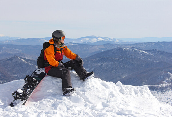 坐在雪山上的滑雪运动员图片