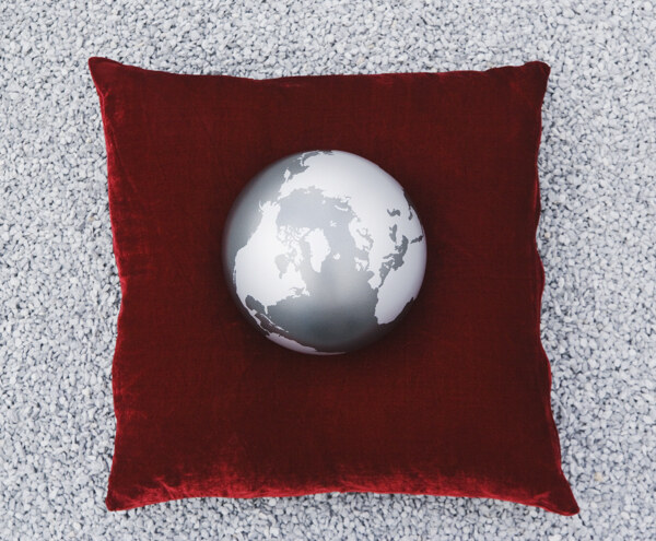 红色抱枕上的灰色地球摄影图片