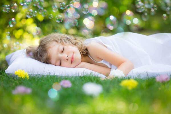 躺在草地上睡觉的小女孩图片