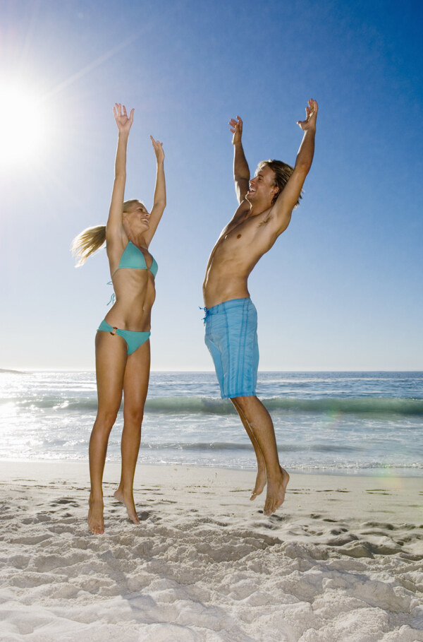 沙滩上跳跃的情侣图片
