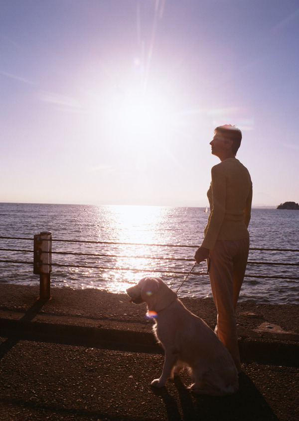 海边夕阳下妇人和狗图片