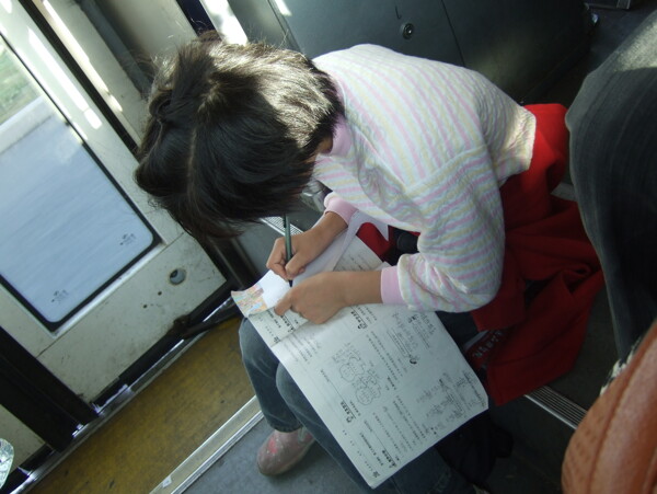 公交上学习的小女孩图片