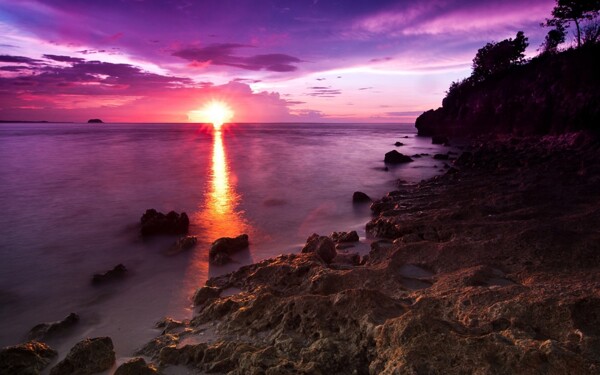夕阳岩石海滩图片