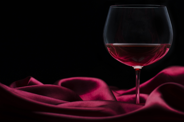 红酒杯子与酒红色布料图片