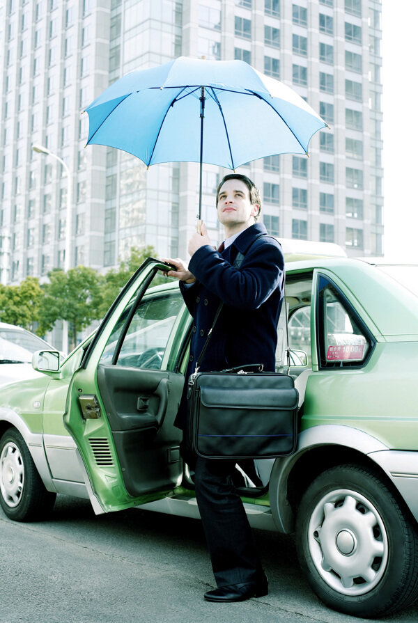 打雨伞遮阳下出租车的商务人物图片