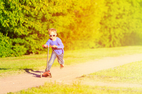 公园玩滑板车的小男孩图片
