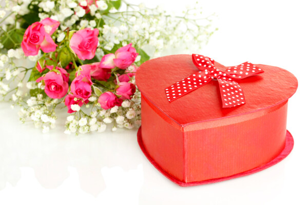 玫瑰花束边的心形礼物盒图片