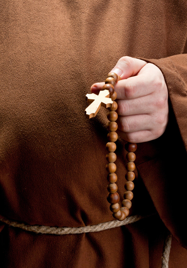 手拿珠链十字架祈祷的男人图片
